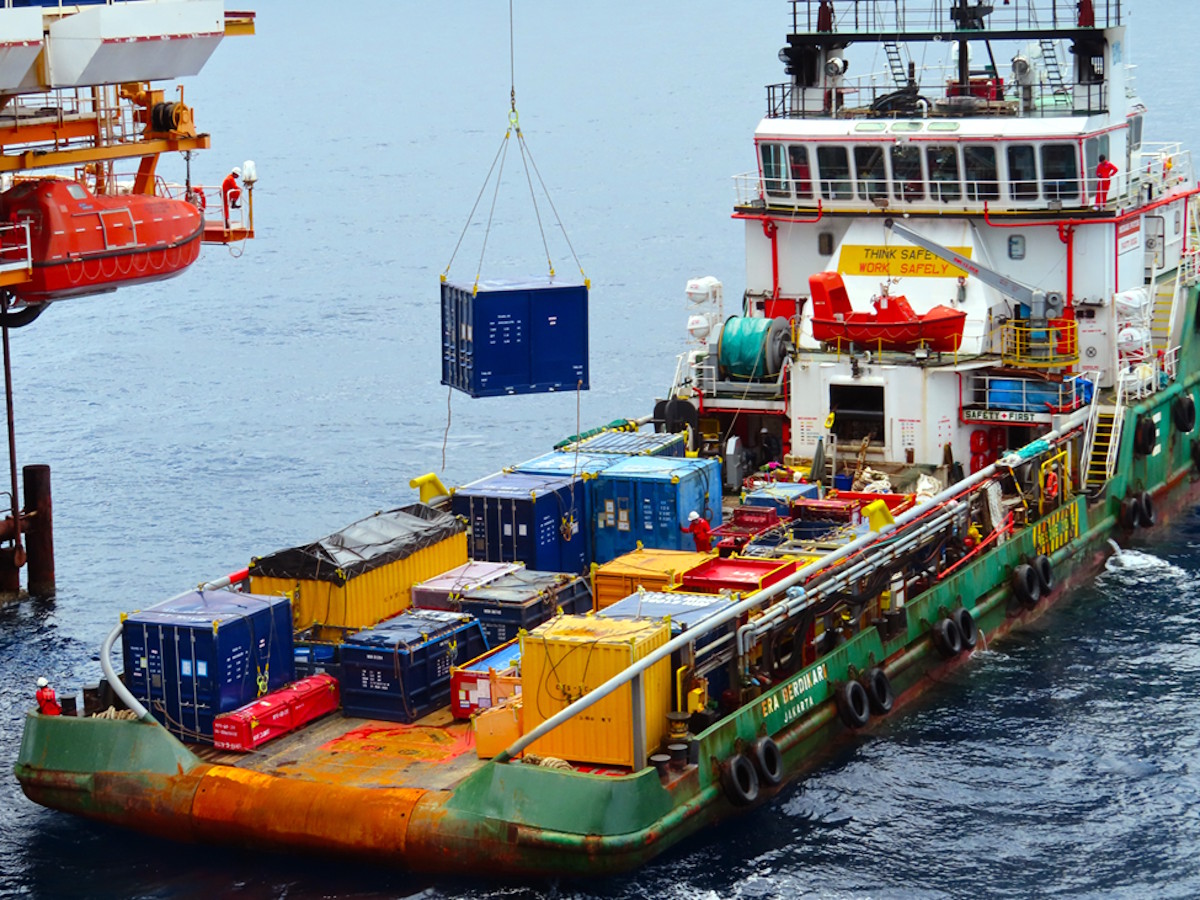 Offshore supply vessel receiving cargo during platform lift operations
